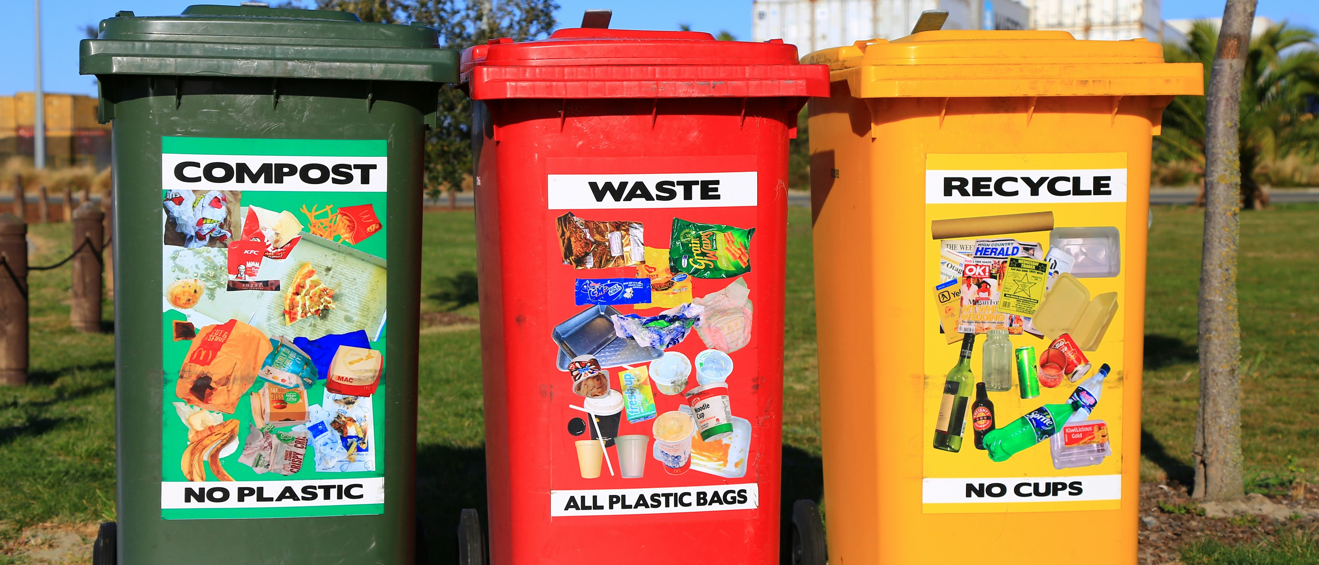 three bright recycling bins split by waste they accept